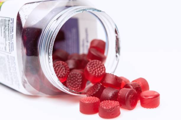 Organic Vegan Gummy vitamins Organic Vegan Gummy vitamins for children coming out of the plastic jar gummy candy stock pictures, royalty-free photos & images