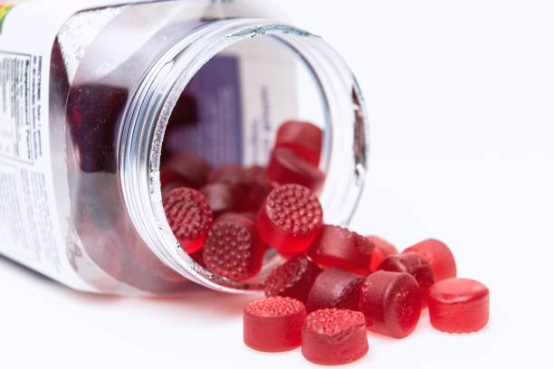 Organic Vegan Gummy vitamins Organic Vegan Gummy vitamins for children coming out of the plastic jar Multivitamin stock pictures, royalty-free photos & images