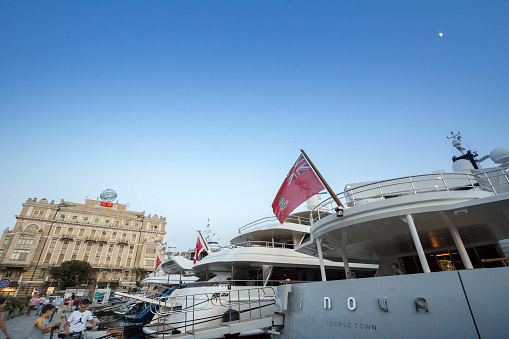 Picture of a yacht bearing the flag of Cayman islands on the port of Rijeka, Croatia, on the waterfront. Cayman islands is a flag of convenience, a business practice whereby a ship's owners register a merchant ship in a ship register of a country other than that of the ship's owners, and the ship flies the civil ensign of that country, called the flag state.