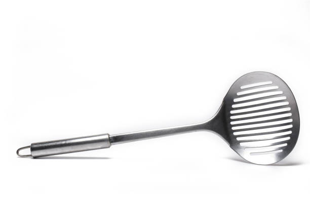 istock Closeup dripping ladle pan turner white background 1363016838