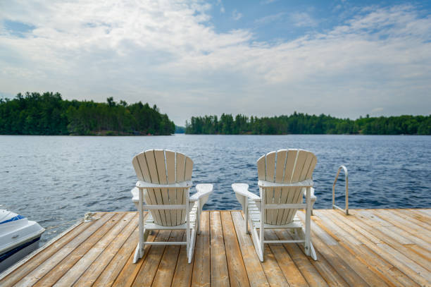istock Two white outdoor chairs on a wooden jetty 1363024163