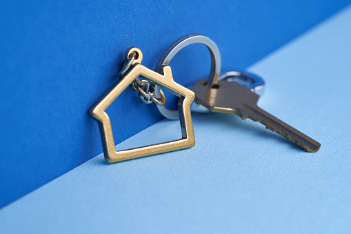 House shaped keychain against blue background