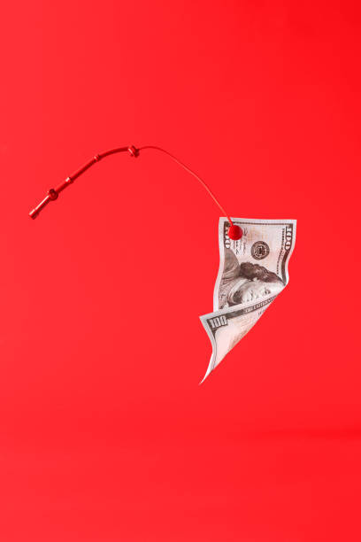 стодолларовая банкнота, пойманная на удочку на красном монохромном фоне, натюрморт - photography still life vertical bill стоковые фото и изображения