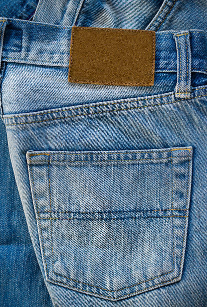 Folded Old Blue Jeans with Blank leather label Highly detailed closeup of  Folded Old Blue Jeans with Blank leather label leather pocket clothing hide stock pictures, royalty-free photos & images