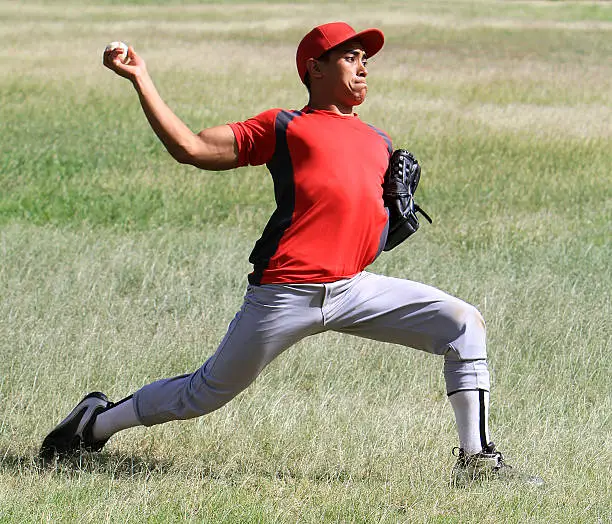 Latino baseball player flings a ball from the outfield with force.