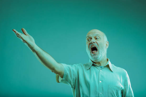 Senior man singing OR complaining at someone gesturing with hand to the side with mouth open - possible Italian gesture to tell somebody off in the distance \