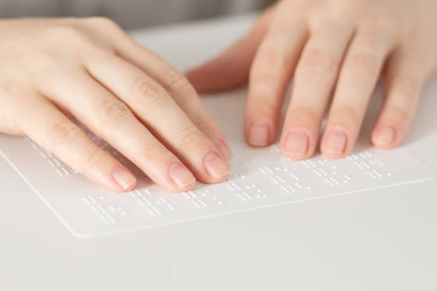 istock alphabet of the blind, hands touch a sheet with raised letters 1363038396