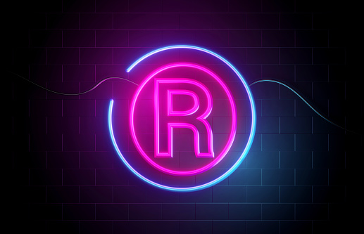 Registered trademark icon neon sign illuminated with blue and purple lights. Marketing And Consumerism Concept.