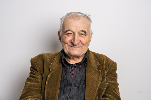 Front view portrait studio shot of one senior caucasian man old pensioner smile