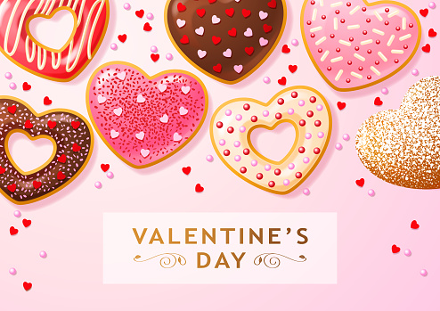 Group of heart shaped donuts coated with colorful sprinkles and powdered sugar for the gift of Valentine's Day treats