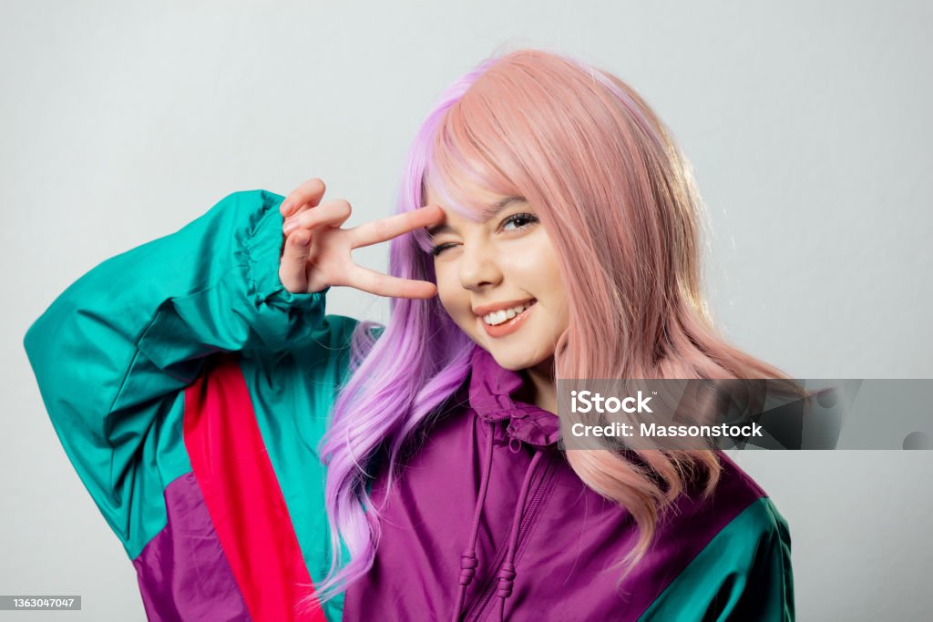 Beautiful yandere girl with purple hair and 80s tracksuit on gray background Cosplay Stock Photo
