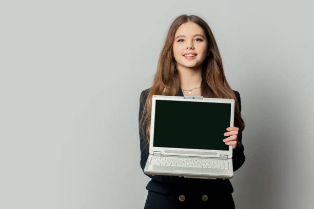 istock Beautiful girl in black jacket with laptop computer on white background 1363047101