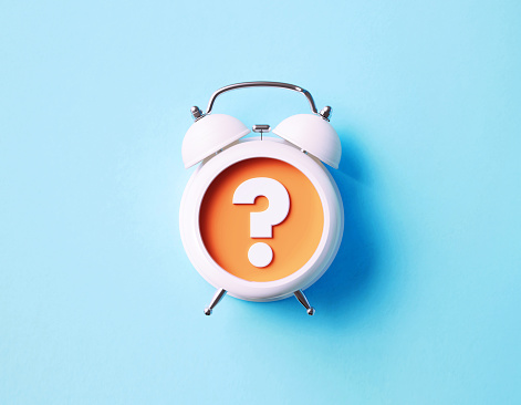 Question mark reads over white alarm clock on blue background. Horizontal composition with copy space.