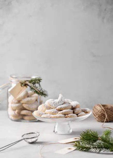 Photo of Cake plate full of homemade vanillekipferln, vanilla cookies dusted with icing sugar.