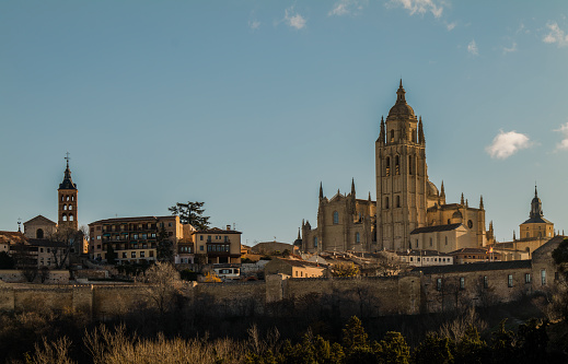 City skyline of Segovia, Spain, with cathedral and church, against blue sky