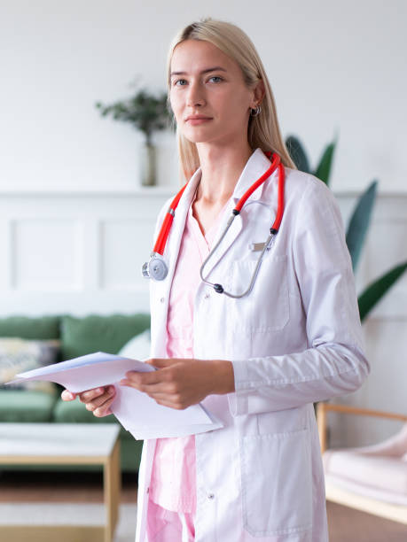 Portrait of young female doctor in white coat. stock photo