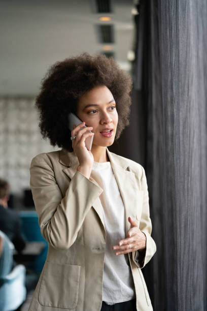 istock Beautiful african corporate worker talking on mobile phone 1363056646