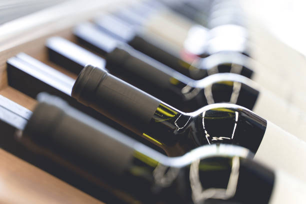 bouteilles de vin avec étiquettes vierges sur le comptoir d’un magasin d’alcool. fond de vin. focus sélectionné - wine cellar photos et images de collection