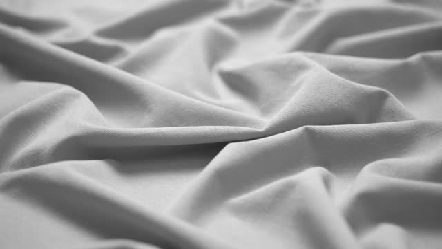 Fabric cloth background. Texture cotton textile material closeup. Wavy pleated fabric on a tailor's table