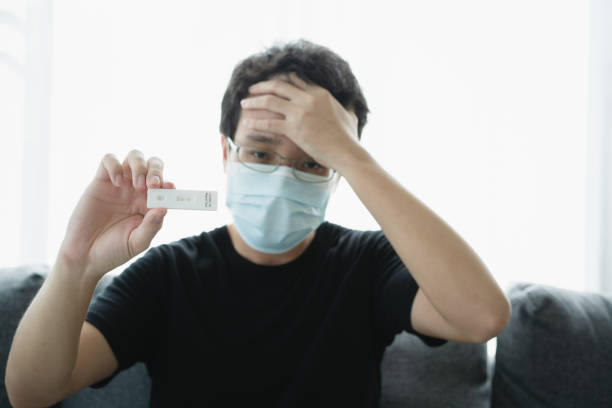 istock Unrecognizable Asian man showing a positive COVID-19 ag testing result 1363061082