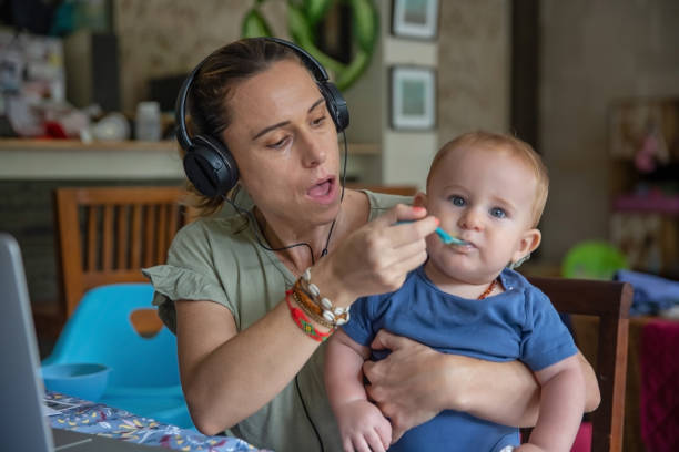 istock Working Mother Feeding Her Baby Boy During Virtual Meeting 1363063249