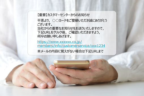 Woman looking at smart phone with scam mail message in Japanese