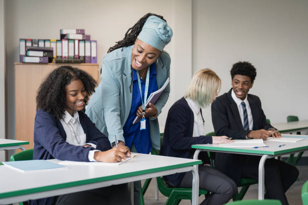 istock Cheerful teacher helping student in secondary classroom 1363069804