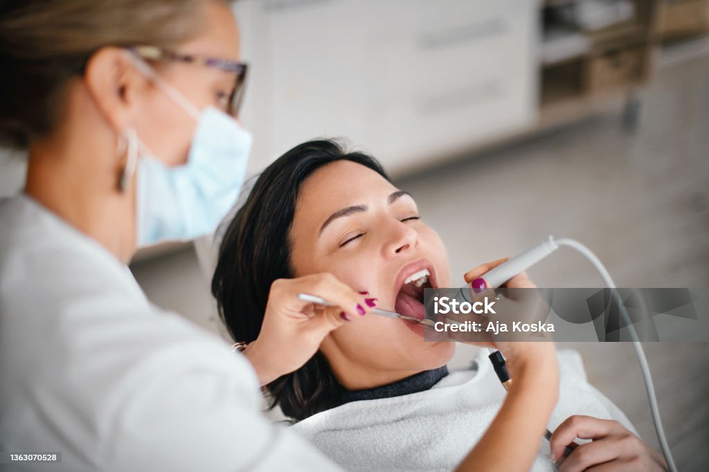 Dentist removing dental calculus. Dentist removing dental calculus from the patient in the dental office. Dental Calculus Stock Photo