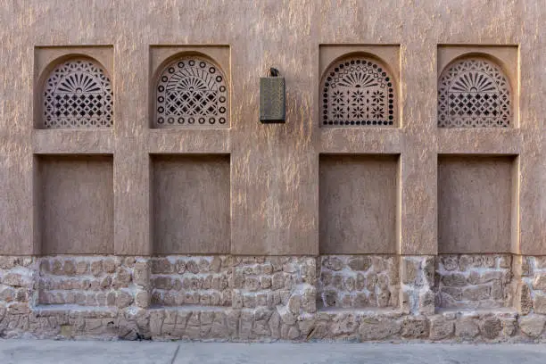 Photo of Arabic style window portals in stone wall with ornaments, traditional arabic architecture, Al Fahidi, Dubai, United Arab Emirates.