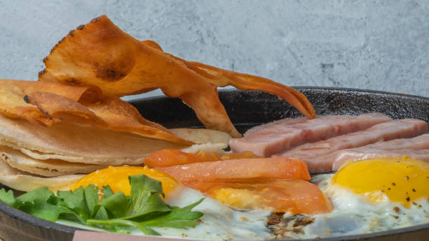 istock Scrambled eggs with ham, tomato and parsley. Scrambled eggs with ham, tomato and parsley. 1363075610