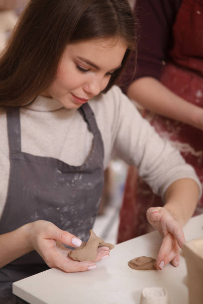 istock Young woman learning from professional potter 1363077193