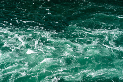 A turbulent background of turquoise colored water aerial.