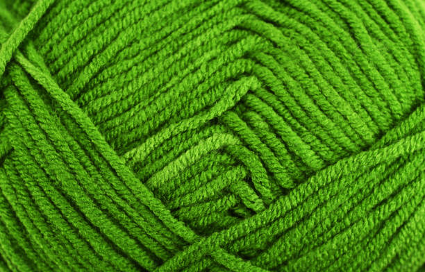istock Green knitting wool close-up.Green yarn clew close up texture. Blue wool background. 1363078785