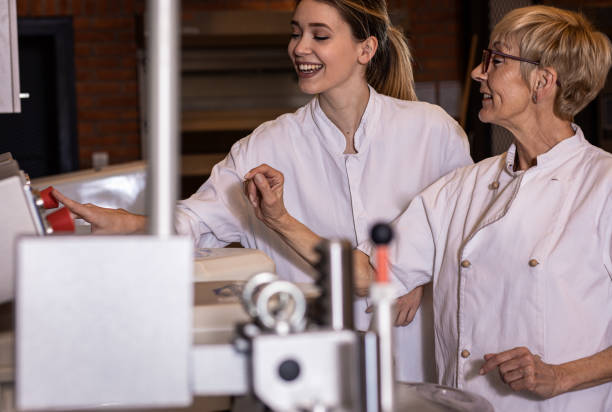 istock Group of bakers in uniform preparing dough for bread in modern manufacturing. 1363081912