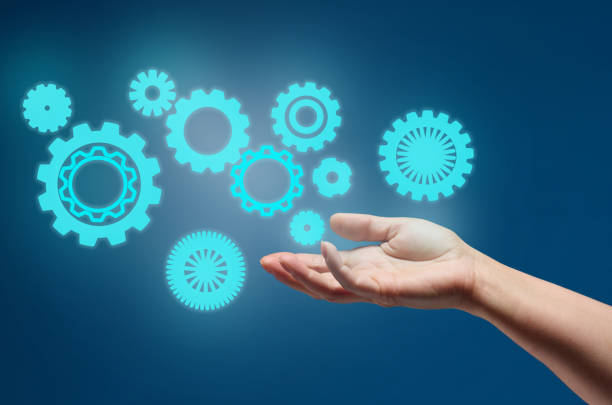 istock gear wheels and female hand on a blue background. Business structure precise work concept, team unification 1363082148