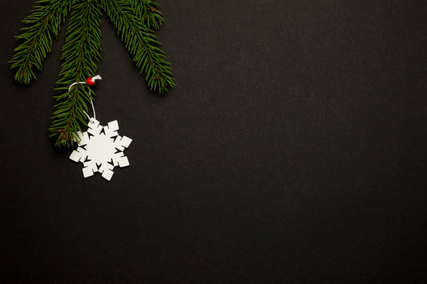 istock Christmas tree with a snowflake toy on a black background. 1363082552