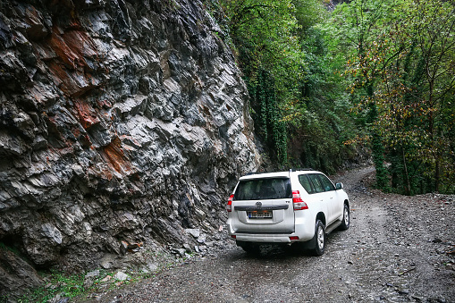Tusheti, Georgia - October 6, 2021: White 4x4 car Toyota Land Cruiser Prado 150 on the high mountainous road of the Caucasus mountains.