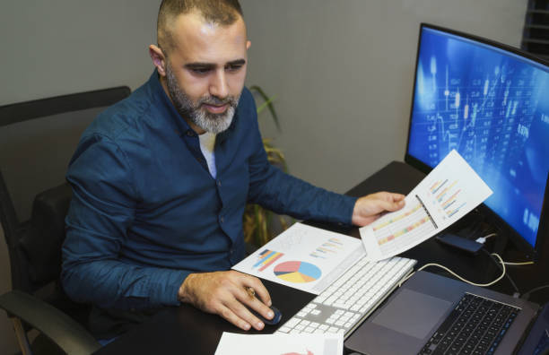 istock Businessman analyzing crypto currency market graphs on computer and laptop screen at home. Bitcoin / Cryptocurrency concept 1363083280
