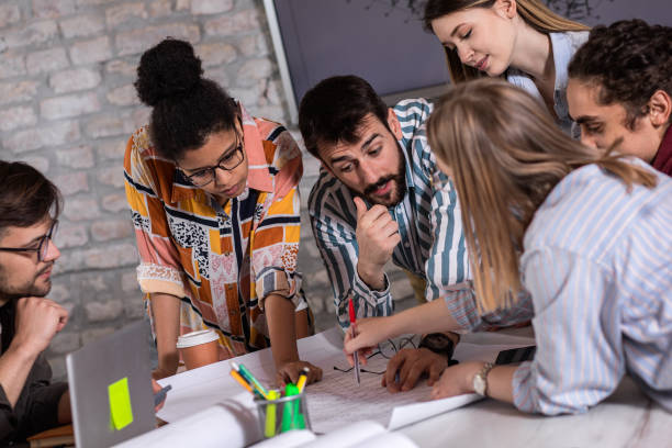 istock Group of young people discussing architectural designs in the creative office. 1363084604