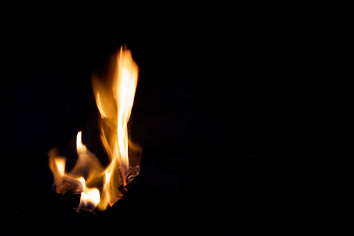 small flame of fire on a black background, horizontal