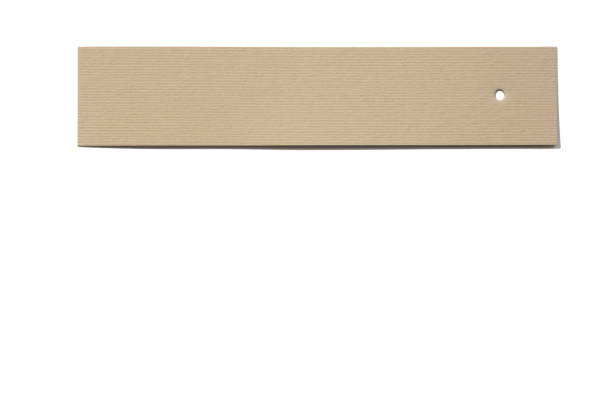istock Brand rectangular tag made of cardboard for items with tiny hole in right side put horizontally on white background with nothing written on it. Tag mock up 1363086163