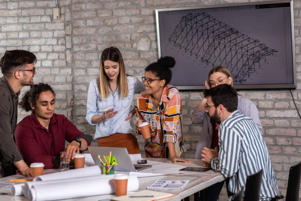 istock Group of young people discussing architectural designs in the creative office. 1363086228