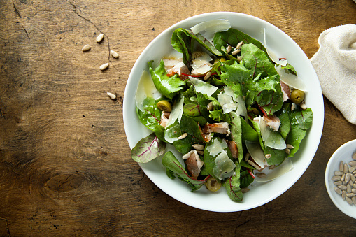 Fresh green salad with olives, bacon and cheese