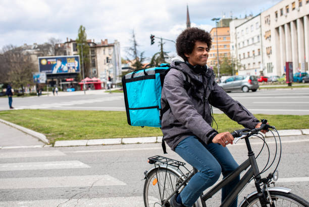 istock Male courier with bicycle delivering packages in city. 1363090332