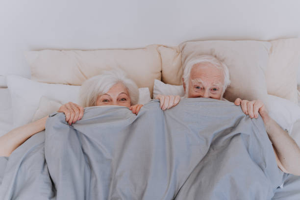 Elderly couple at home Beautiful senior couple enjoying time together at home - Romantic moments at home, elderly couple in bed at home flirting stock pictures, royalty-free photos & images