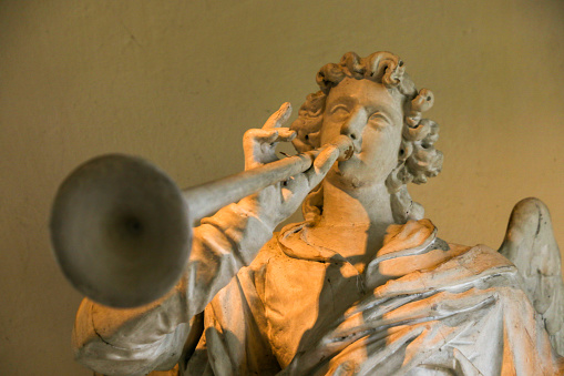 Sculptures of a trumpet angel on an baroque altar