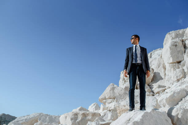 istock man in classic clothes, jacket, tie and glasses is posing on the mountain. 1363095893