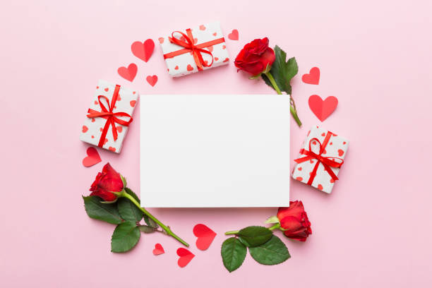istock Frame made of rose, git box, heart and blank greeting card mockup on Colored background. Top view, flat lay, copy space Holiday, Mothers Day, birthday concept 1363096836