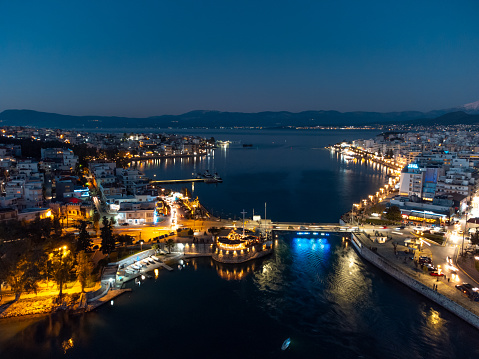 Aerial panoramic photo of the old bridge and the city center of Halkida, Chalkida in Evia, Greece at night
