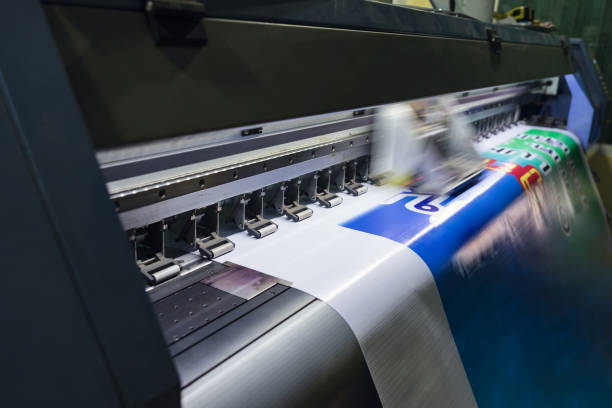 impresora de inyección de tinta de gran formato que trabaja en papel de vinilo en el lugar de trabajo - impimiendo fotografías e imágenes de stock